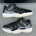 Jordan 11 lace-up sneakers with black and gray panels, white midsole, cream outsole