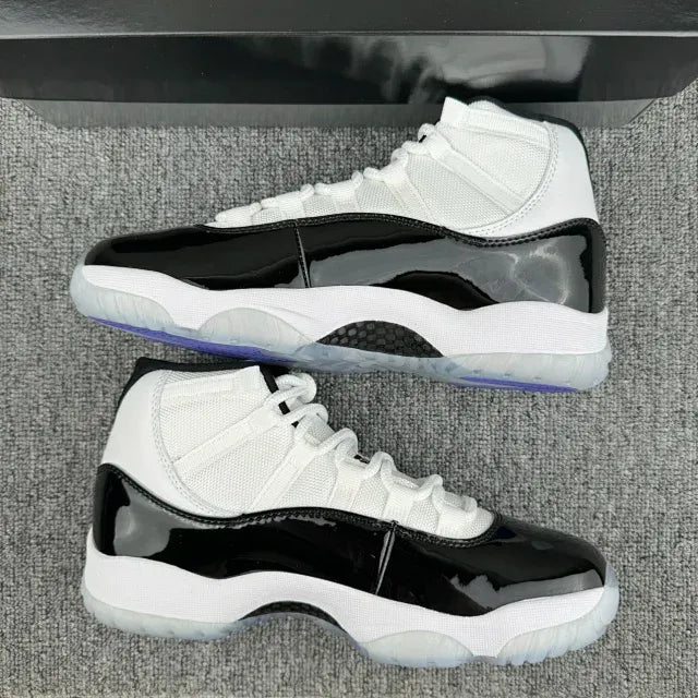 White and black mid-top sneakers with glossy panels and white laces