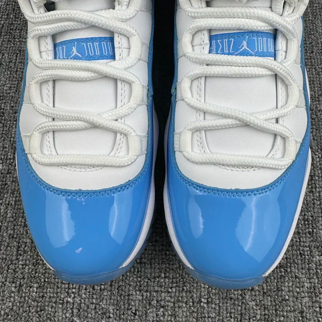 Front close-up of white and blue low-top sneakers with lace eyelets and logo