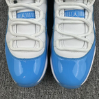 Front close-up of white and blue low-top sneakers with lace eyelets and logo