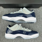 Pair of low-top Jordan 11 sneakers, cream upper with navy panels, white midsole