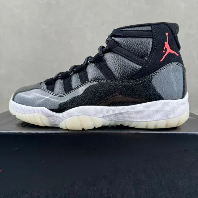 Black and gray Jordan 11 high-top sneakers with red Jumpman on side, white midsole