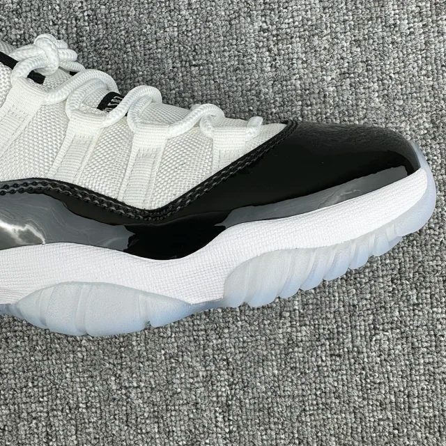 White and black low-top sneaker close-up of glossy black side panel and sole