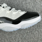 White and black low-top sneaker close-up of glossy black side panel and sole