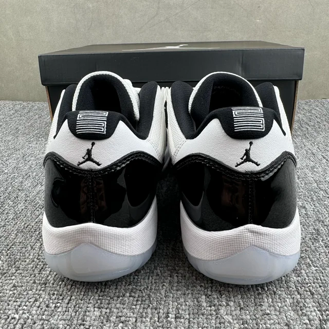 White and black low-top sneakers rear view with Jumpman logo on heel
