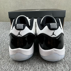 White and black low-top sneakers rear view with Jumpman logo on heel