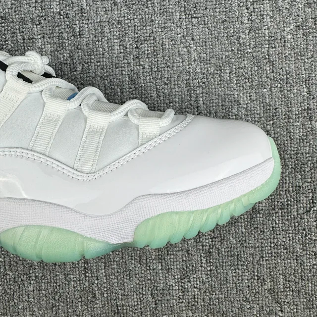 Close-up of white sneaker upper with laces, stitching, and green sole edge