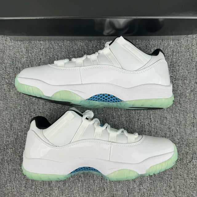 Pair of white low-top sneakers with green sole and blue patterned midfoot panel