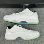 Pair of white low-top sneakers with green sole and blue patterned midfoot panel