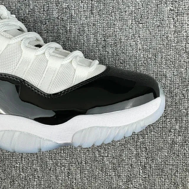 White and black mid-top sneakers, side view with textured detailing and white sole