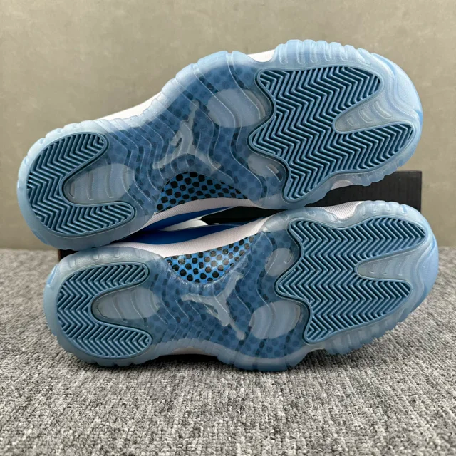 Outsole view of white and blue low-top sneakers with blue herringbone tread