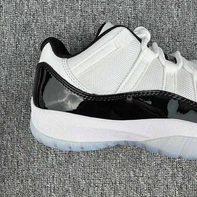 White and black low-top sneaker with mesh upper and glossy black toe section