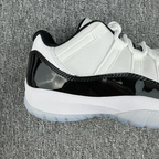 White and black low-top sneaker with mesh upper and glossy black toe section