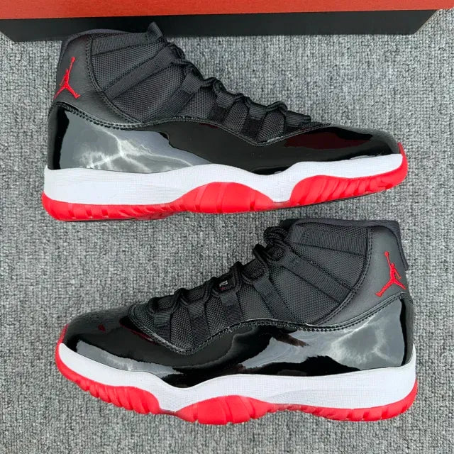 Black high-top sneakers with red lace accents, white midsole, and Jumpman side logo