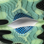 Close-up of sneaker outsole with translucent green rubber and blue dot insole