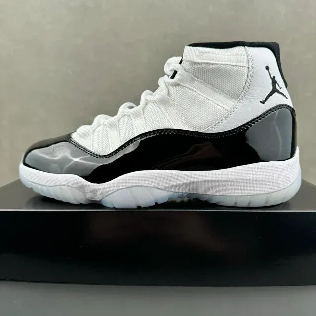 White mid-top sneakers with black heel panel and Jumpman logo on side