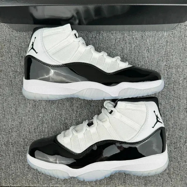 Pair of white and black mid-top sneakers on gray carpet, front and side views
