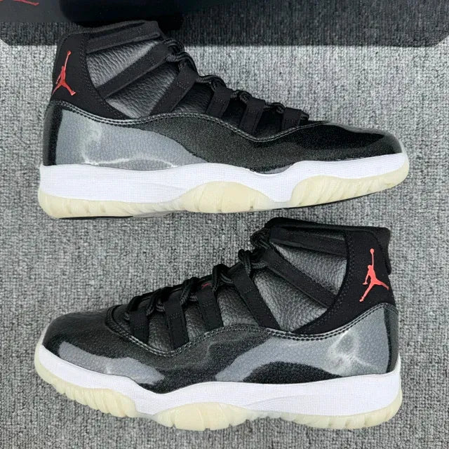 Black Jordan 11 high-top sneakers with gray patterning, red Jumpman, white and gum sole