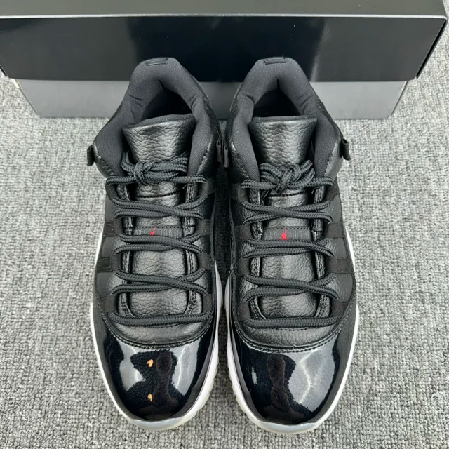Jordan 11 lace-up sneakers with black-and-gray uppers and speckled graphic detail