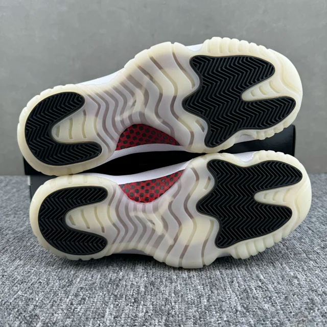 Jordan 11 outsoles with black zigzag tread and red accent, cream rubber