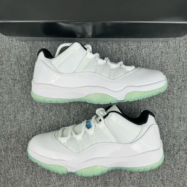 White low-top sneakers with green outsole and blue side accent detail