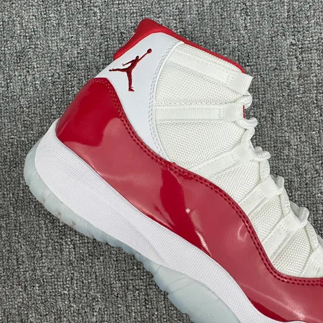 Side view of red and white high-top sneaker with glossy red panel and lace overlay