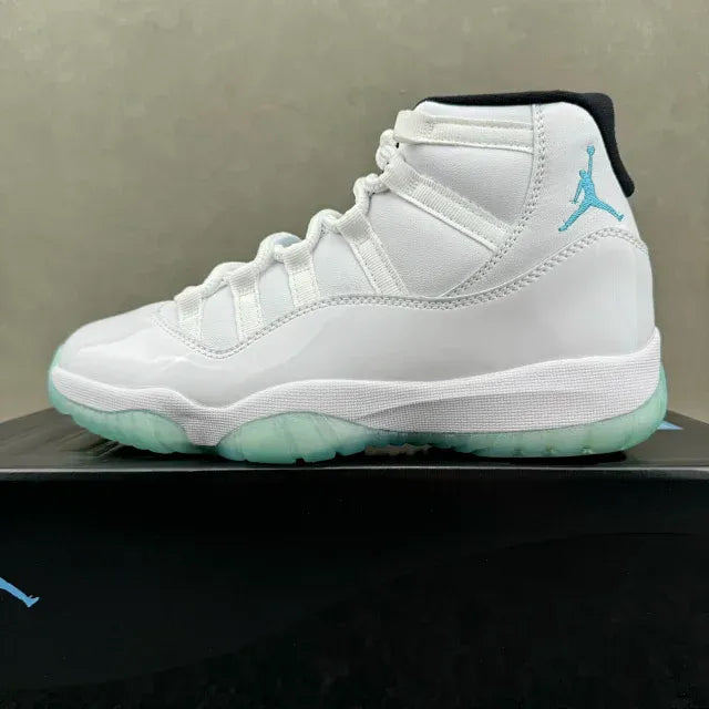 White Air Jordan 11 high-top sneaker on box, teal Jumpman logo and mint-green sole