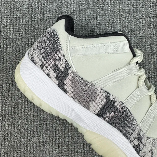 Low-top sneaker showing side quarter with gray-and-black snakeskin print and white leather panel