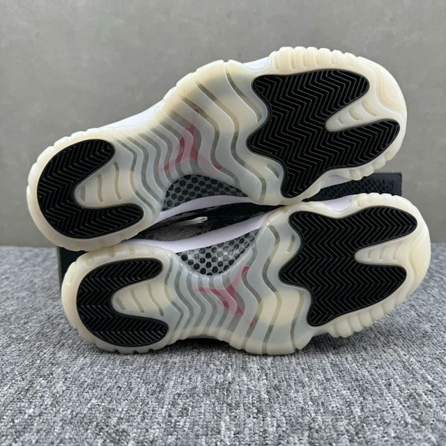 Two low-top sneaker outsoles stacked, showing off-white tread with black rubber sections