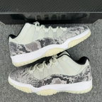 Two low-top snakeskin sneakers, white uppers with gray-and-black pattern and off-white sole