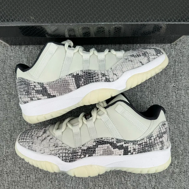 Two low-top snakeskin sneakers, white uppers with gray-and-black pattern and off-white sole