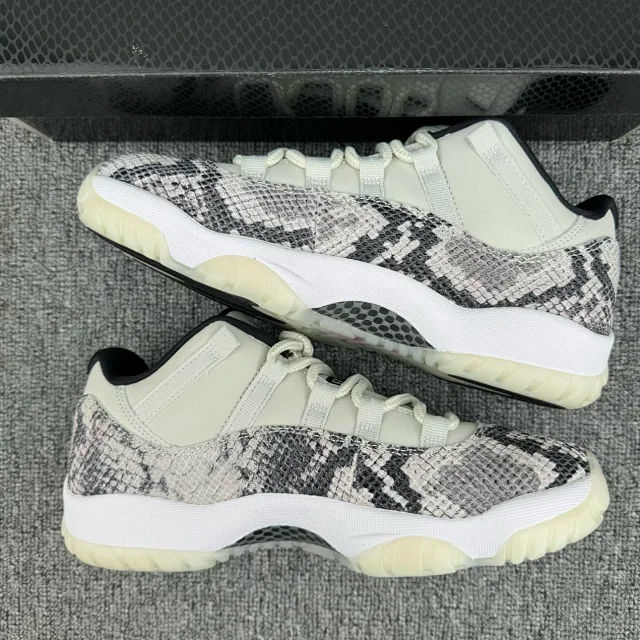 Pair of low-top snakeskin sneakers with white uppers, black-gray pattern, and off-white soles