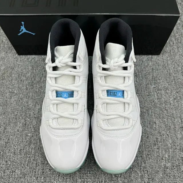 Pair of white Air Jordan 11 high-top sneakers with teal accents and mint-green outsole