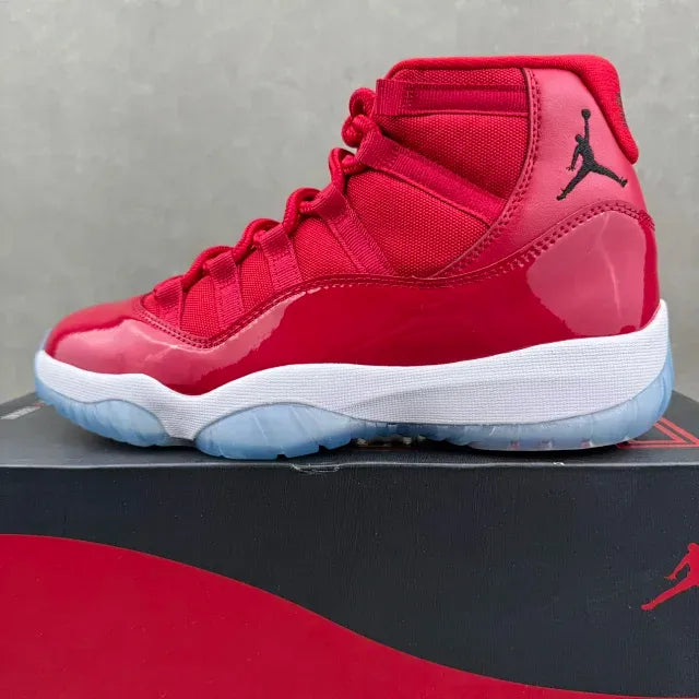 Red high-top sneaker with lace-up front, black Jumpman logo, and blue sole