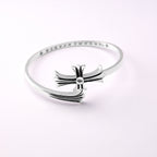 Chrome bangle bracelet with bow ornament centered on a slim pavé band