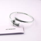 Chrome bangle bracelet with bow centerpiece and etched side pavé stones
