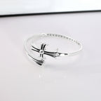 Chrome bangle bracelet with bow centerpiece centered on the reflective band