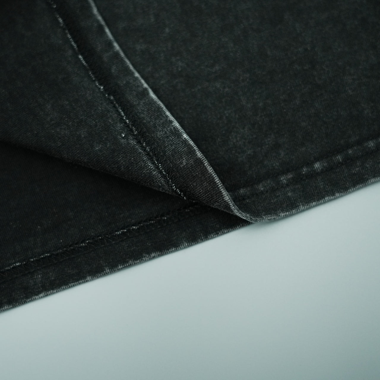Black T-shirt fabric close-up with stitched seams