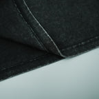 Dark gray T-shirt fabric close-up with stitched seams and folded hem