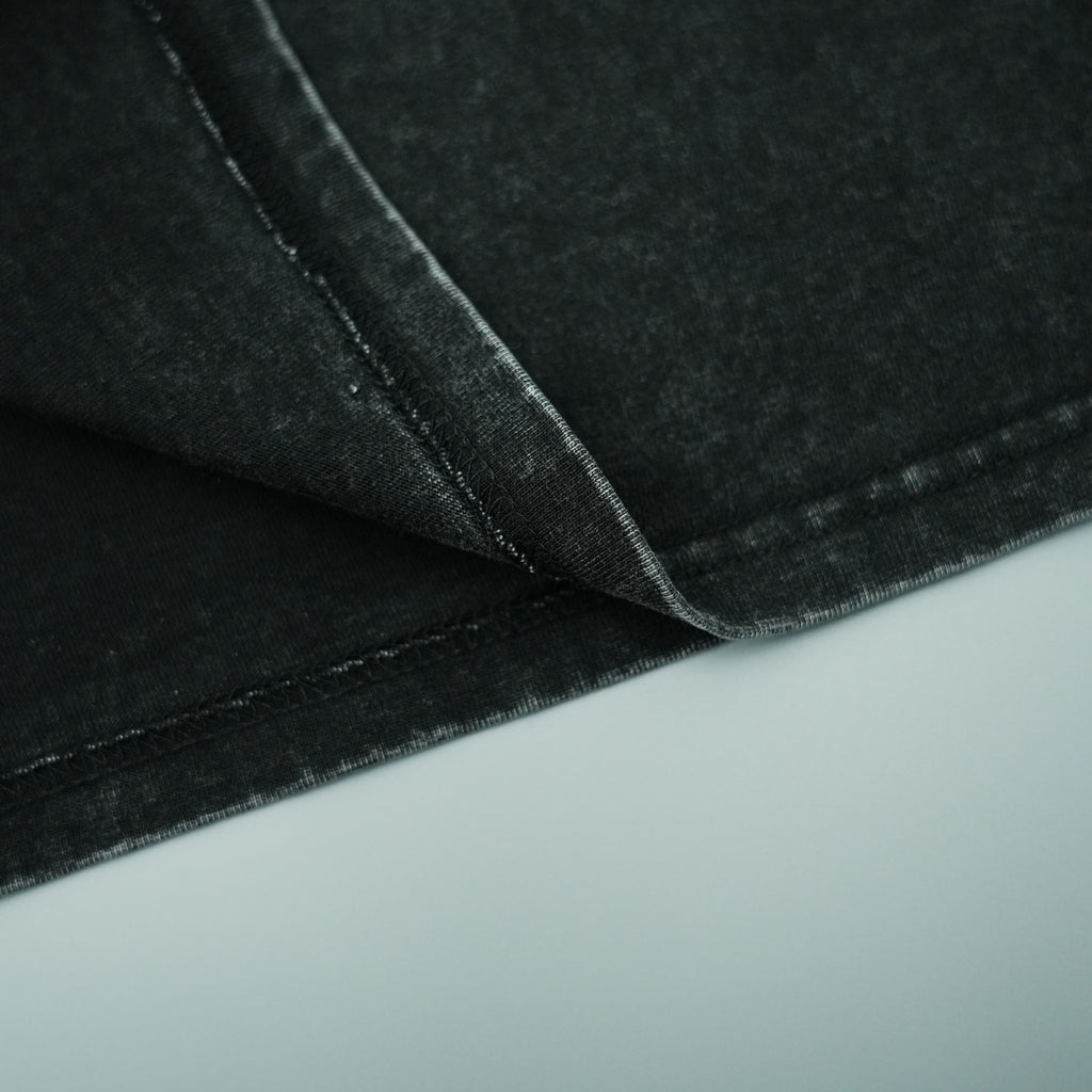 Black T-shirt fabric with stitched seams and folded texture