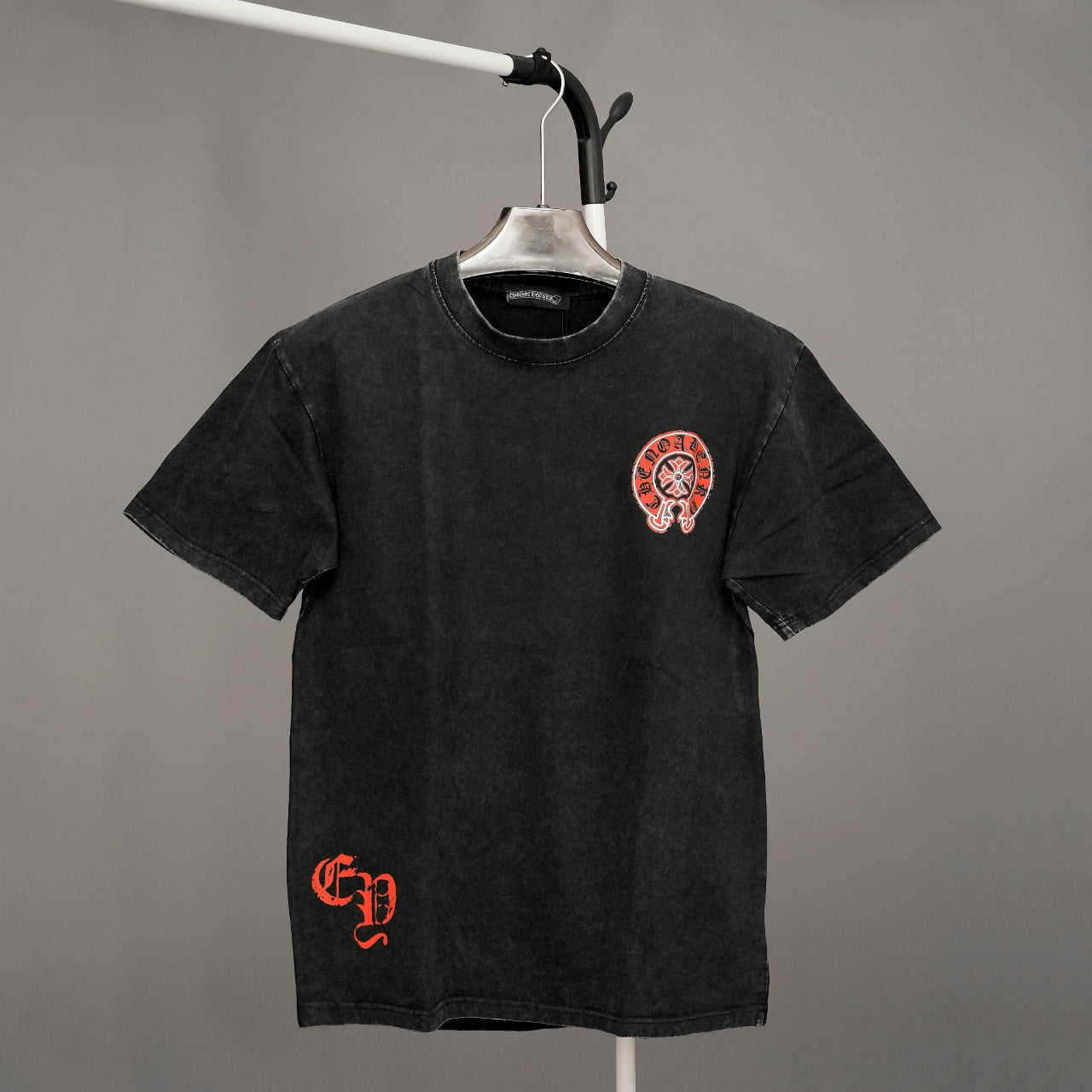 Black graphic T-shirt with small red chest emblem on front, crew neck