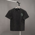 Black graphic T-shirt with small green emblem on left chest and crew neck