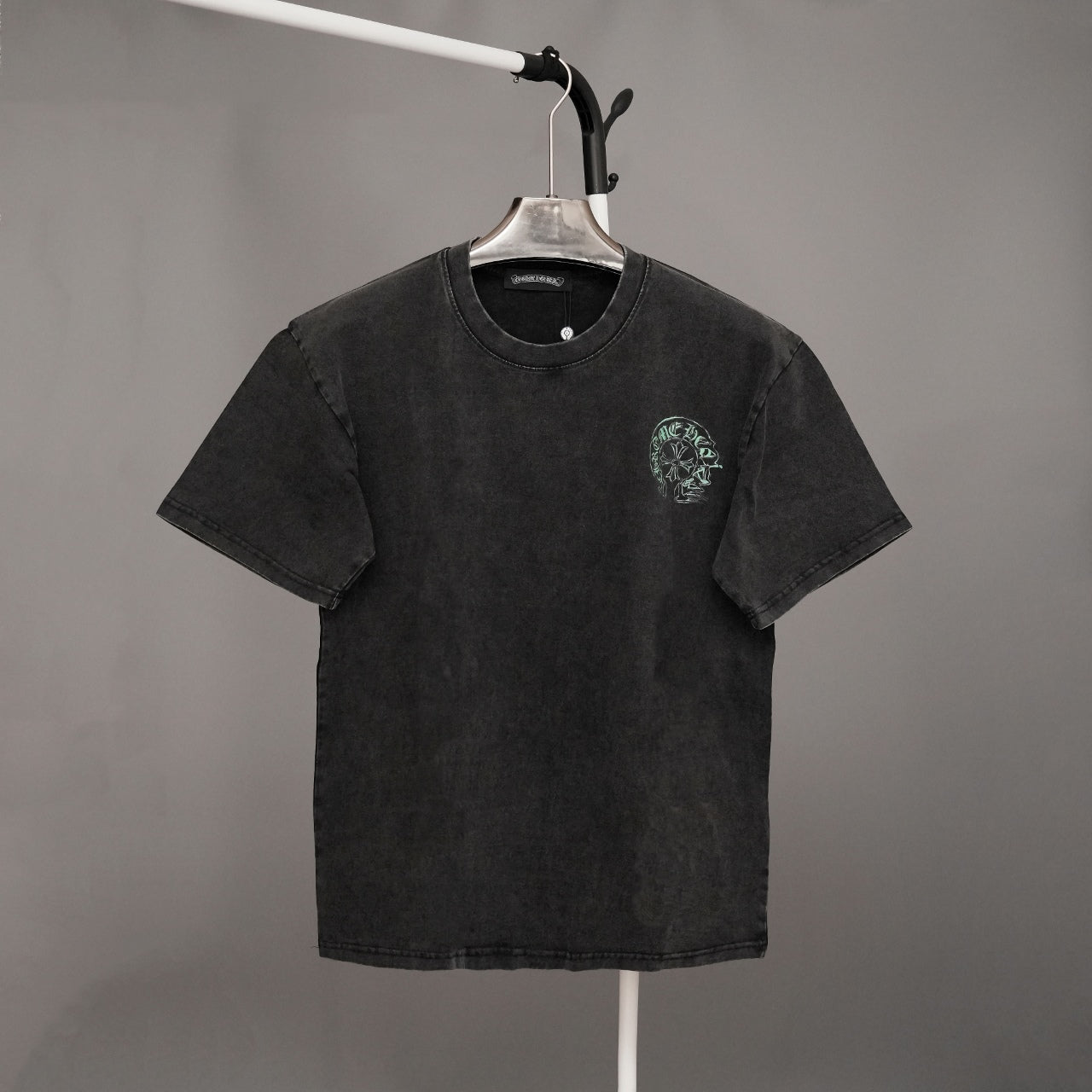 Black graphic T-shirt with small green emblem on left chest and crew neck