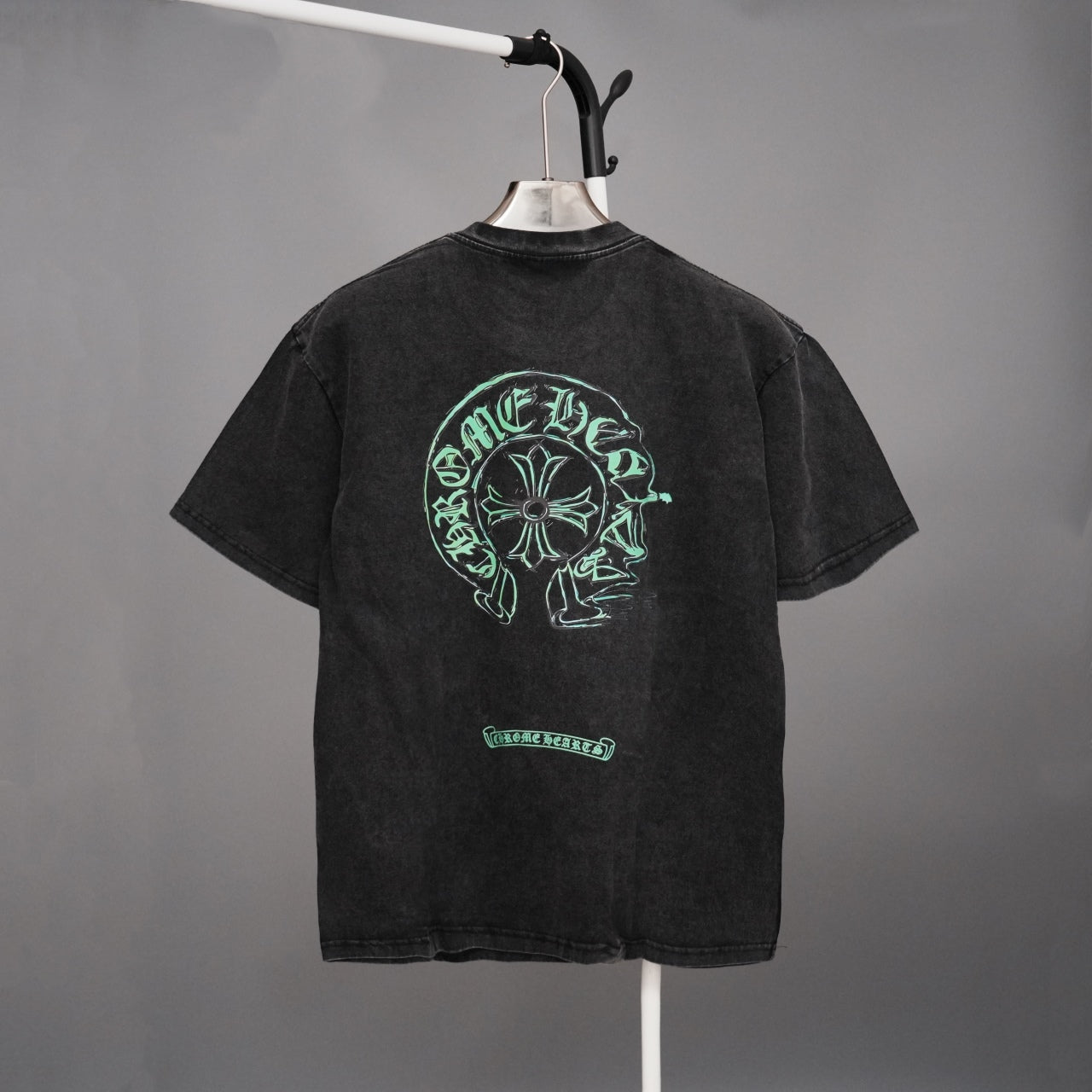 Black graphic T-shirt with large green head emblem on back and small chest graphic