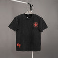 Black short-sleeve T-shirt with red crest logo on chest and small red mark