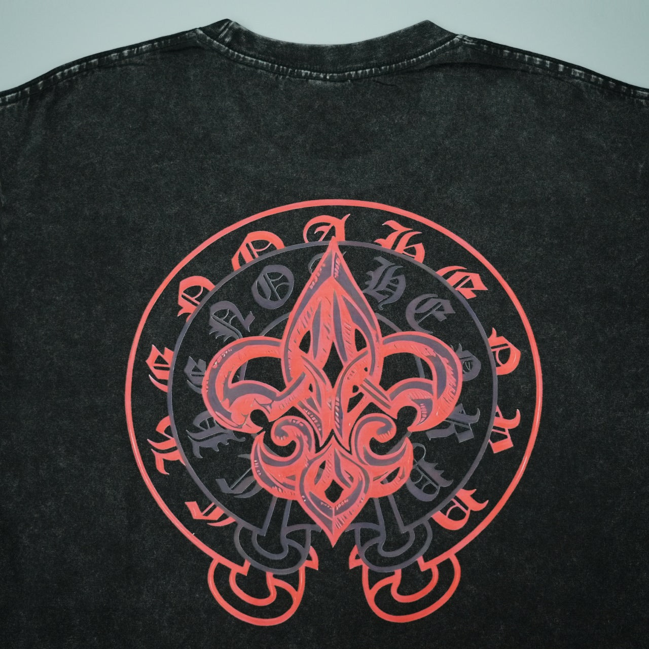 Black short-sleeve T-shirt back with large red fleur-de-lis style emblem