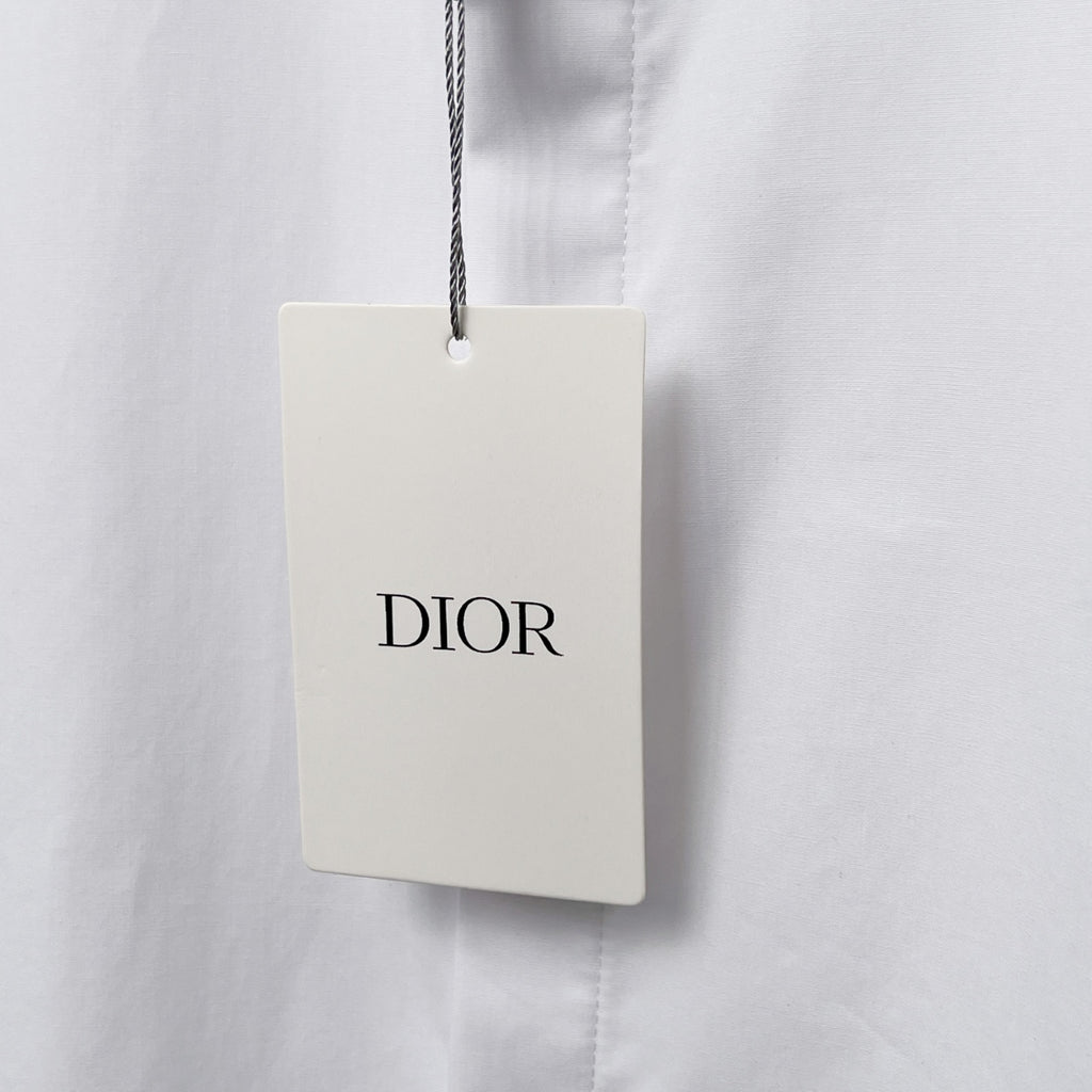 Dior clothing tag on white shirt, DIOR logo on hanging label