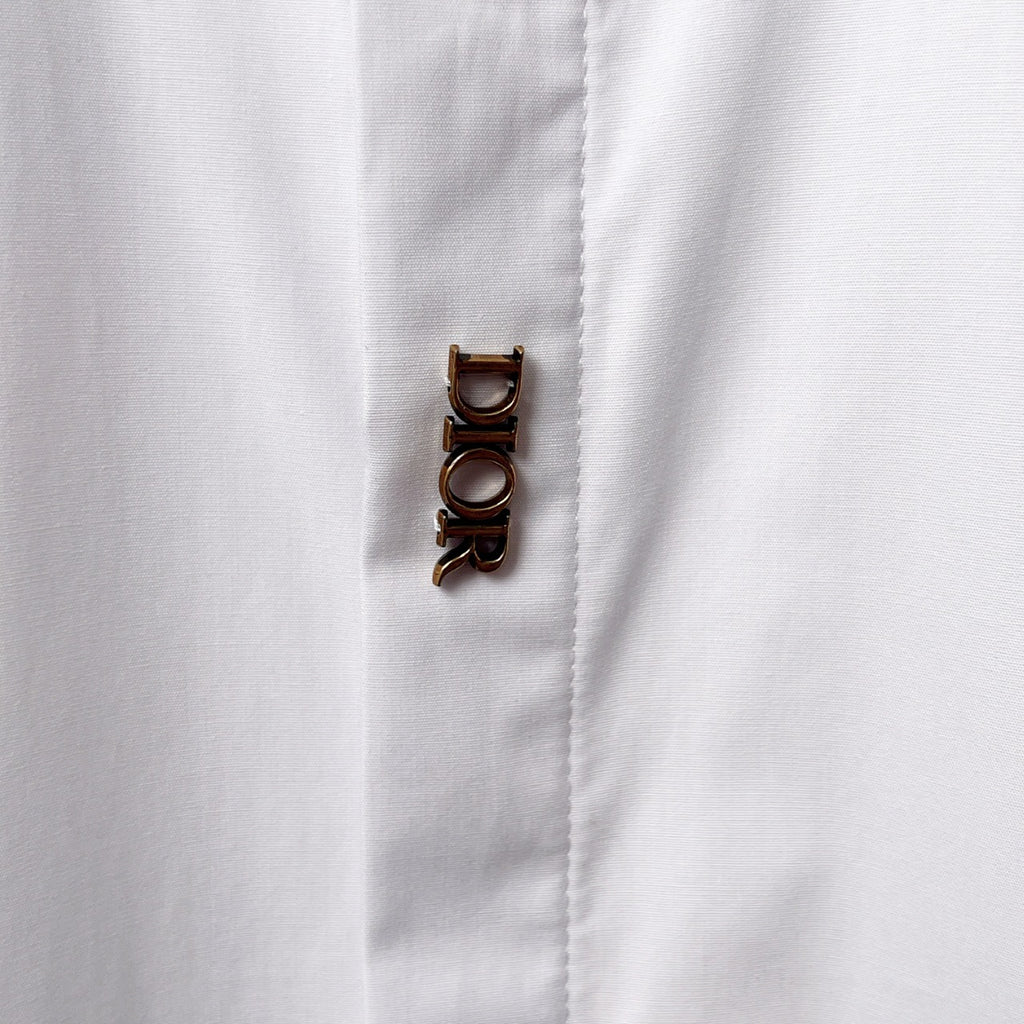 Dior long-sleeve shirt cuff with button detail, white fabric close-up
