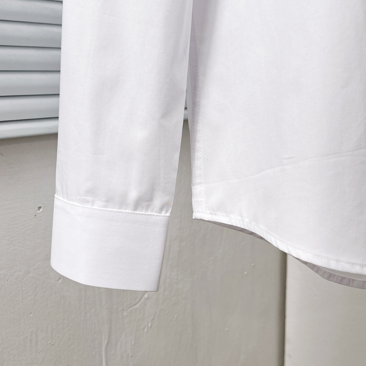 Dior long-sleeve shirt hem and sleeve cuff, white, side close-up