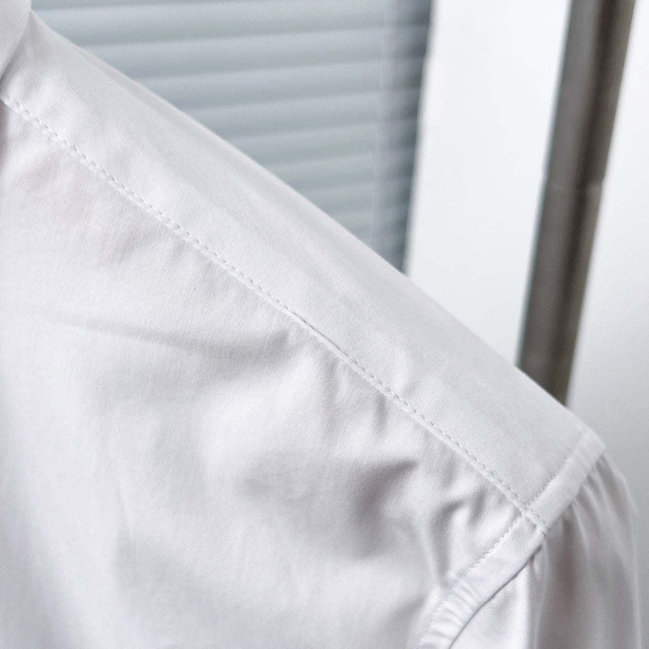 Dior long-sleeve shirt shoulder seam detail, white fabric close-up